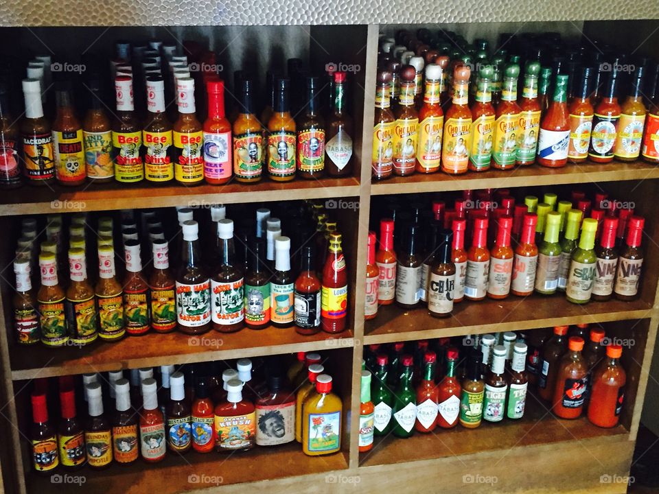 Hot sauce on a shelf. Variety of hot sauces 