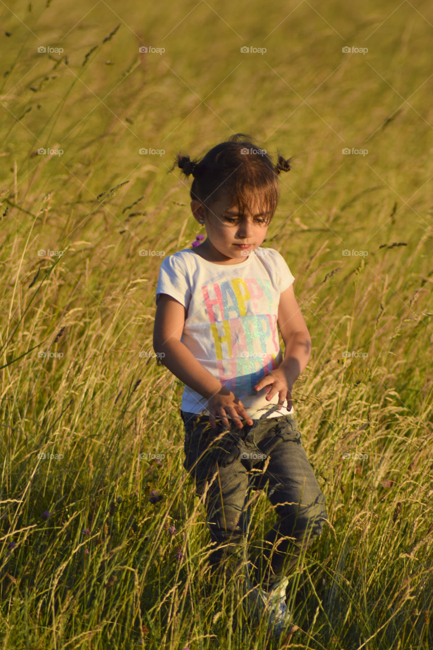 Child in the field at sunset