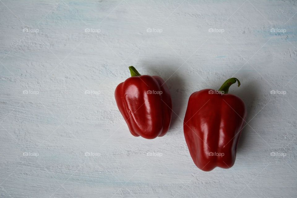 two red peppers on a white top view background