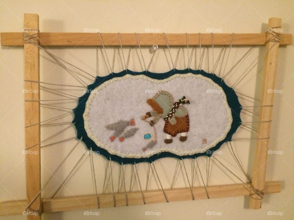 Inuit wall hanging of a woman catching fish. 
