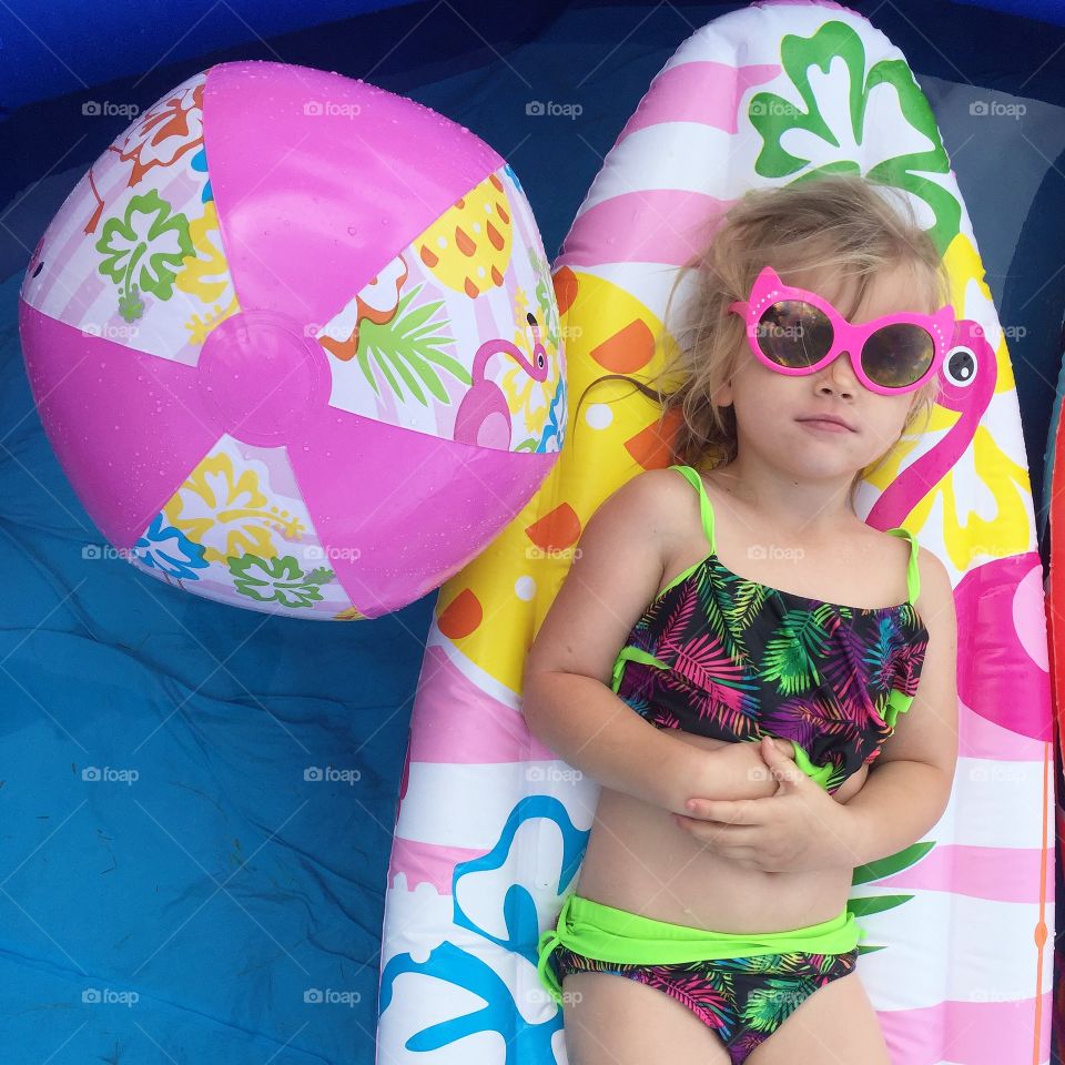 Girl in bikini lying on inflatable bed