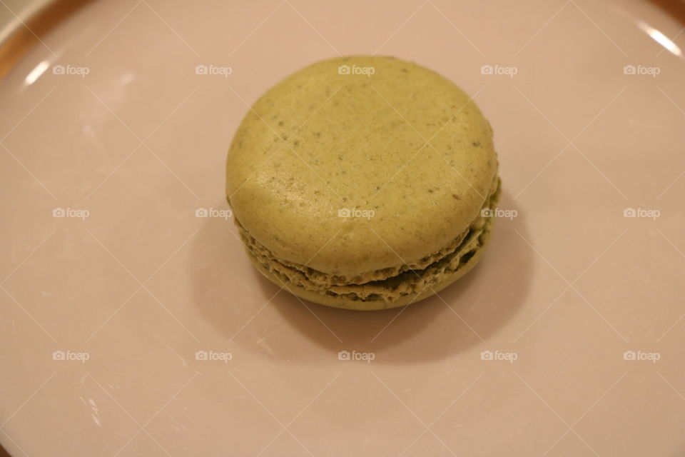 Green macaroon on a white plate