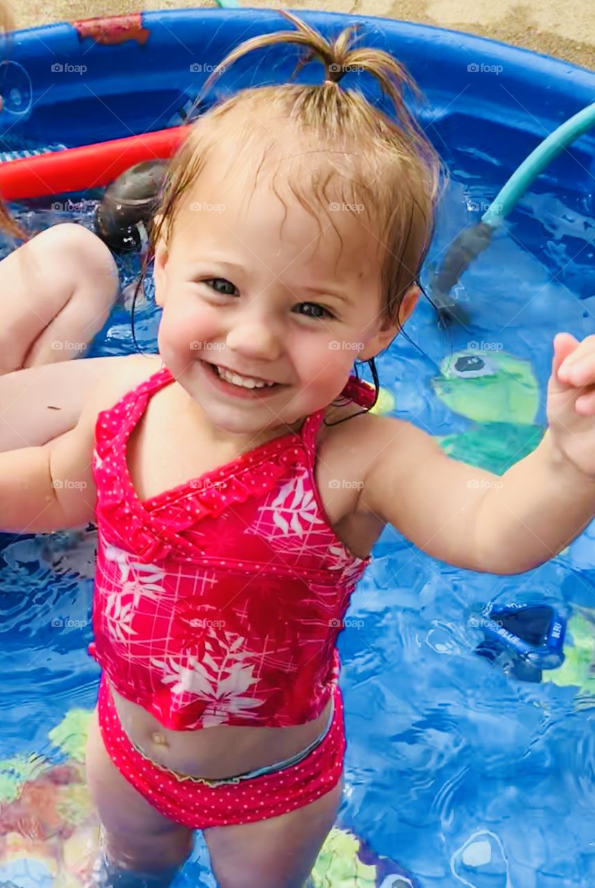 Smiling toddler girl in swimming pool