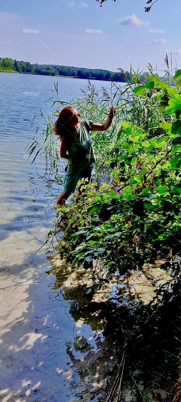 Wading through the water at lakeshore with your pants rolled up in the „Lüneburger Heide“ in Germany is a glorious and refreshing pastime on a hot summer afternoon. 2022. Hypnotic Productions