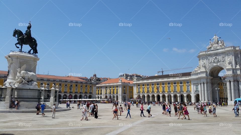 a massive historic plaza in the European downtown of Lisbon, Portugal with many pedestrians