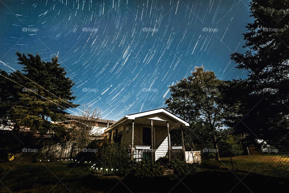 Star trails behind house
