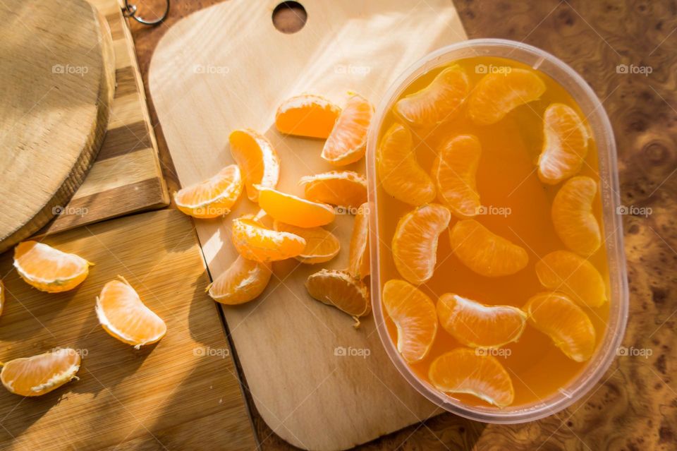 Delicious orange jelly with tangerine slices in a container and jelly worms.