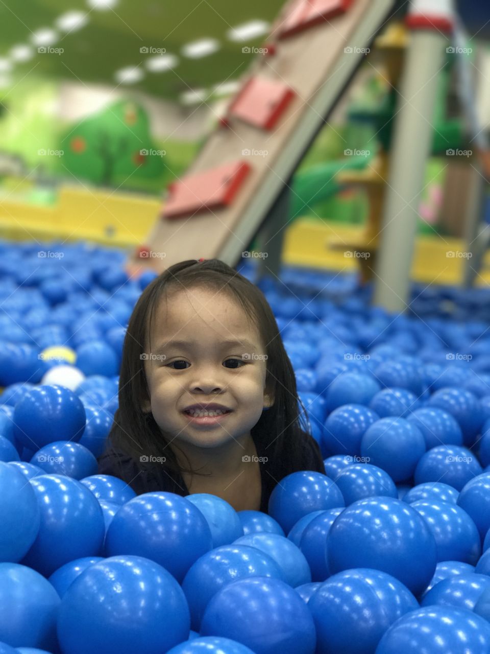 Happy girl sitting on blue balloon