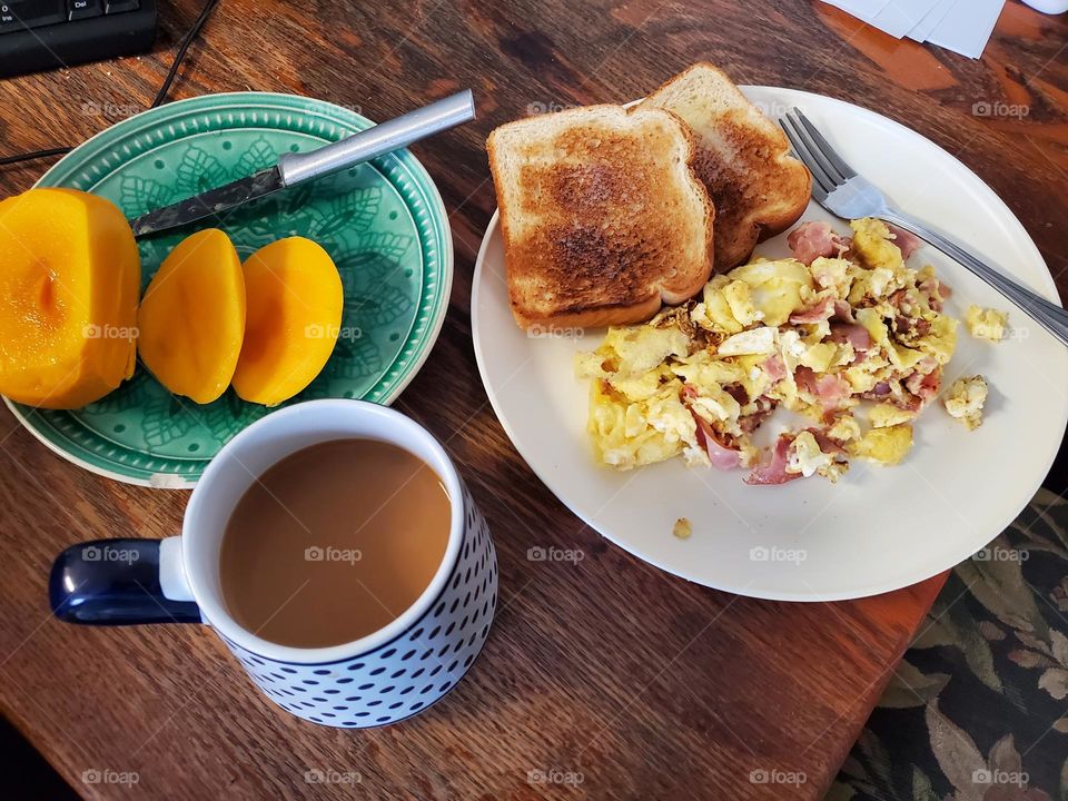 revoltillo de huevos con Jamón, tostadas con mantequilla, Cafe con crema y mangos.(scramble eggs with ham, toast with butter, coffee and cream and mangos)