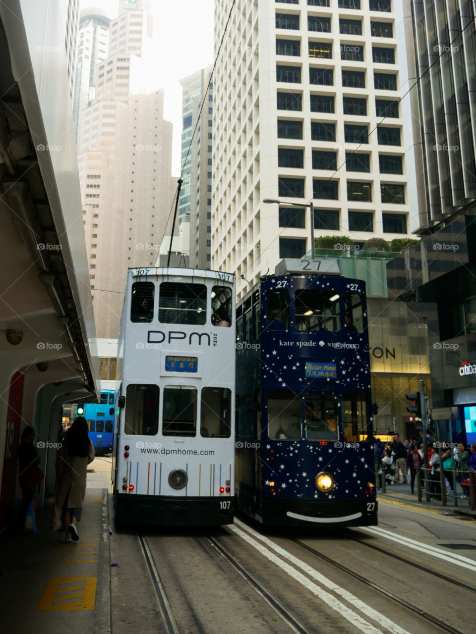 A white and black tram cars in Hong Kong Central. Getting places during the day.