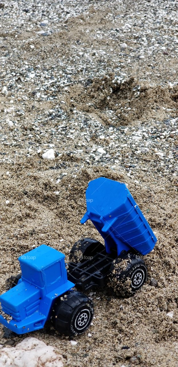blue toy truck in the sand