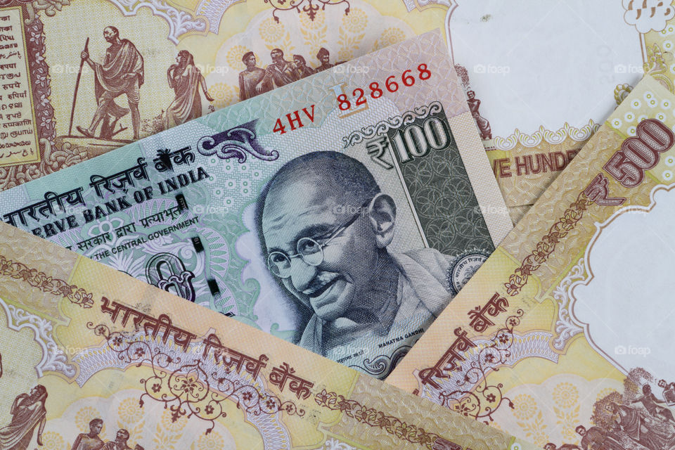 Indian currency rupee 100 in between rupees 500 notes