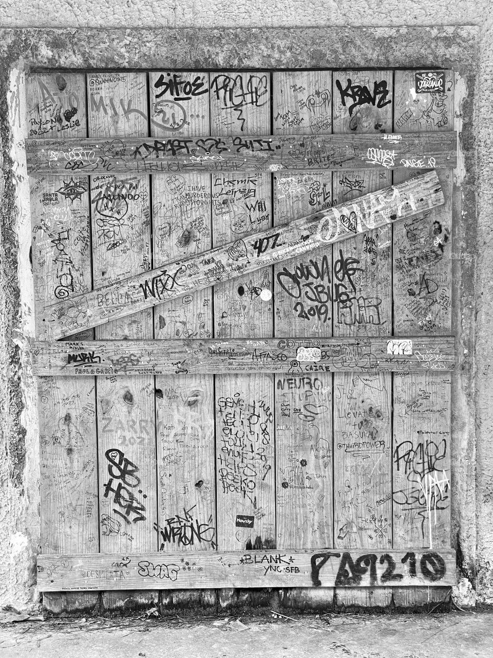 A wooden door in a building covered in graffiti 