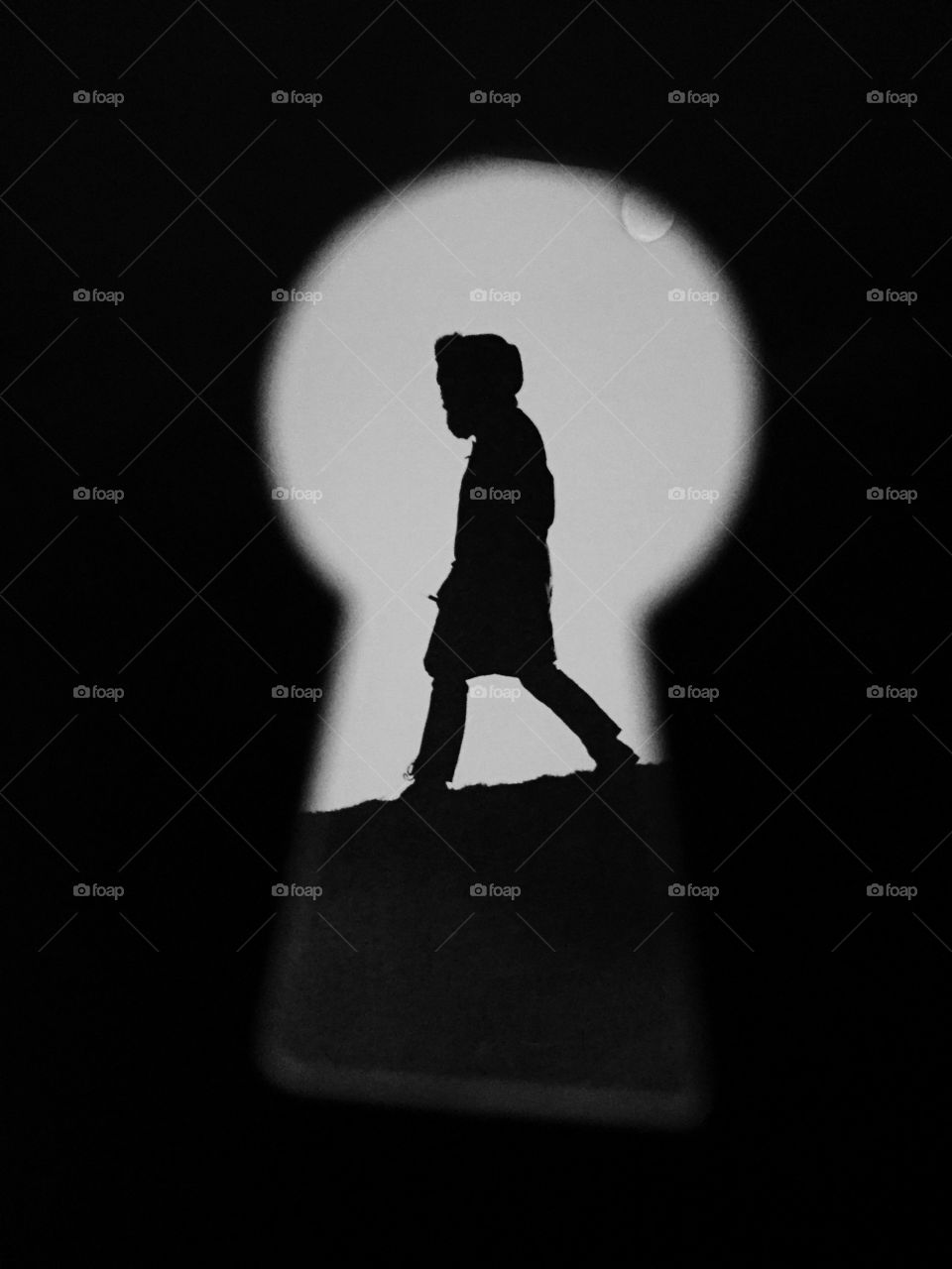 Silhouette of person seen through keyhole