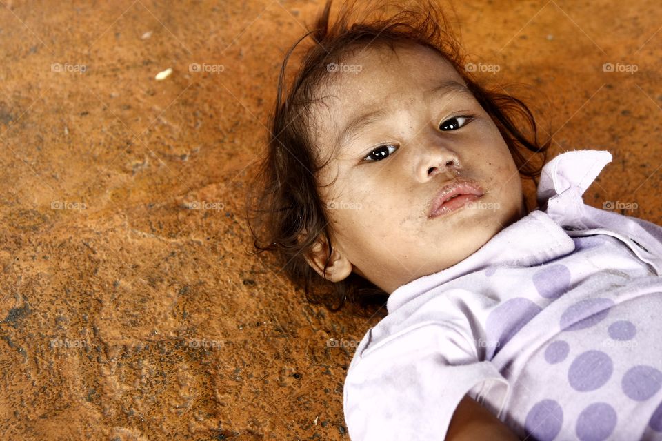 young girl lying down. young street girl lying down on a pavement