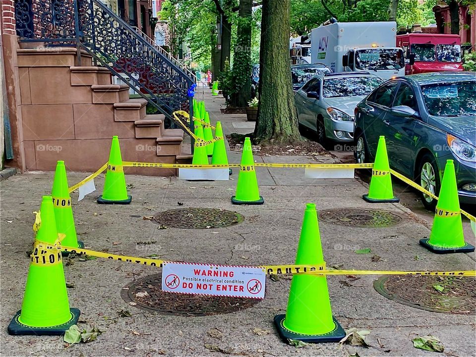 „WARNING- DO NOT ENTER“ is printed on the sign tied around the neon green plastic barricades on „Waverly St“ off of „Fulton St“ in Brooklyn, NY 2022. Hypnotic Productions