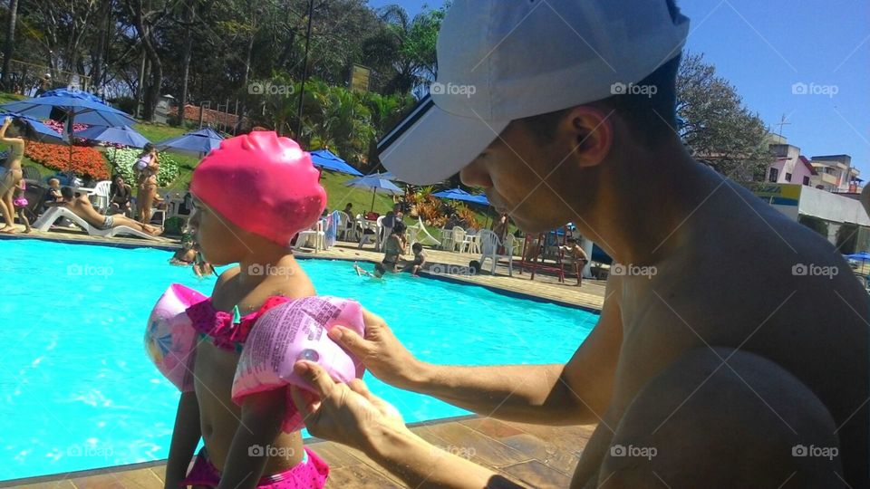 Dad preparing his daughter for a day of pool