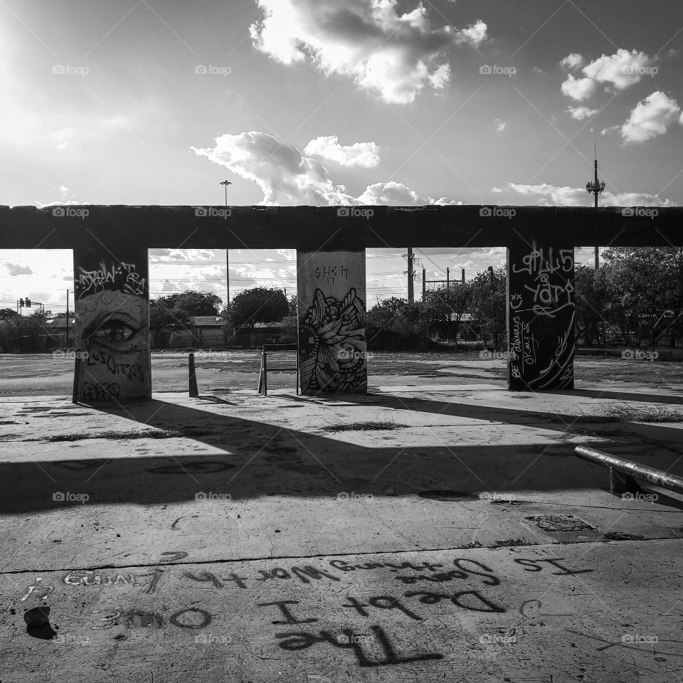 The debt I owe... in black and white.   Urban street art and graffiti at an abandoned deteriorated facility as the sun sets creating shadows.