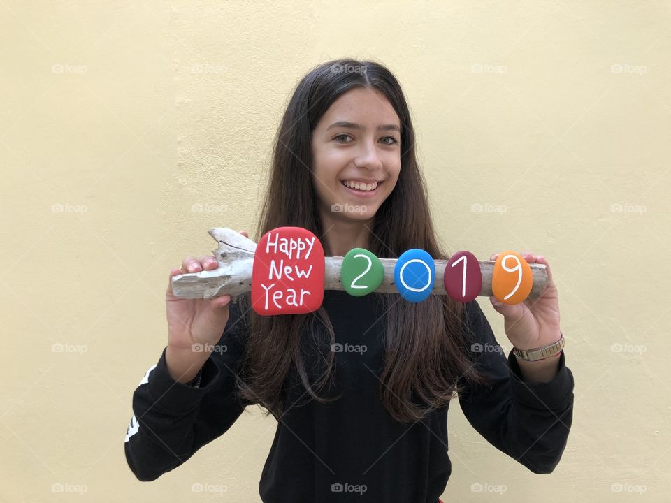 Happy New Year 2019 with colored stones with a young smiling girl