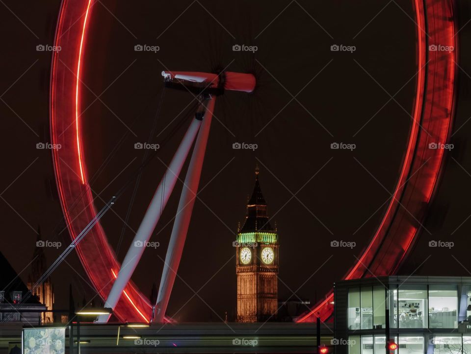 Big Ben Clock Tower seen through a spinning London eye, with empty offices and a passing train