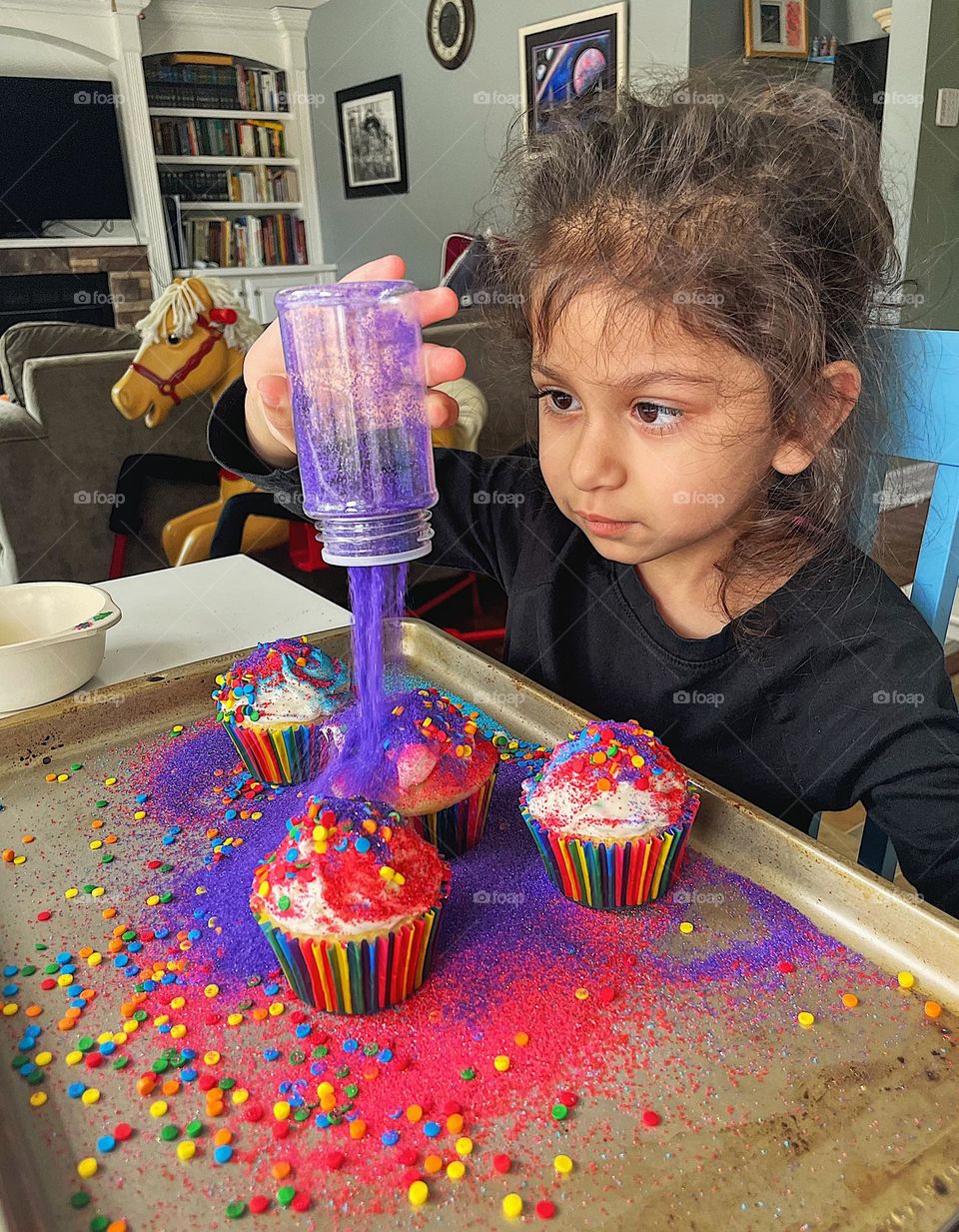 Toddler decorating cupcakes with sanding sugar, toddler dumps sugar on cupcakes, toddler messes in The kitchen, baking with toddlers 