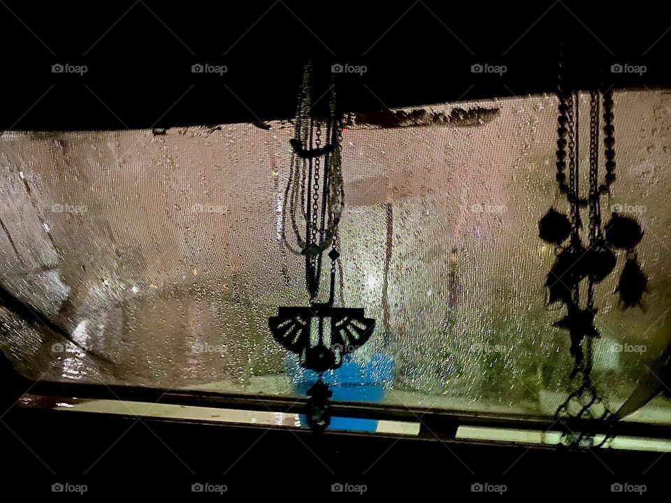 It is night aboard “Salvation”, our “28 ft 1969 Luhrs” at “Newtown Creek” in LIC, Queens. The backlight from outside casts shadows on the window as it appears. Moisture from condensation and raindrops add to the allure. 2023. Hypnotic Productions