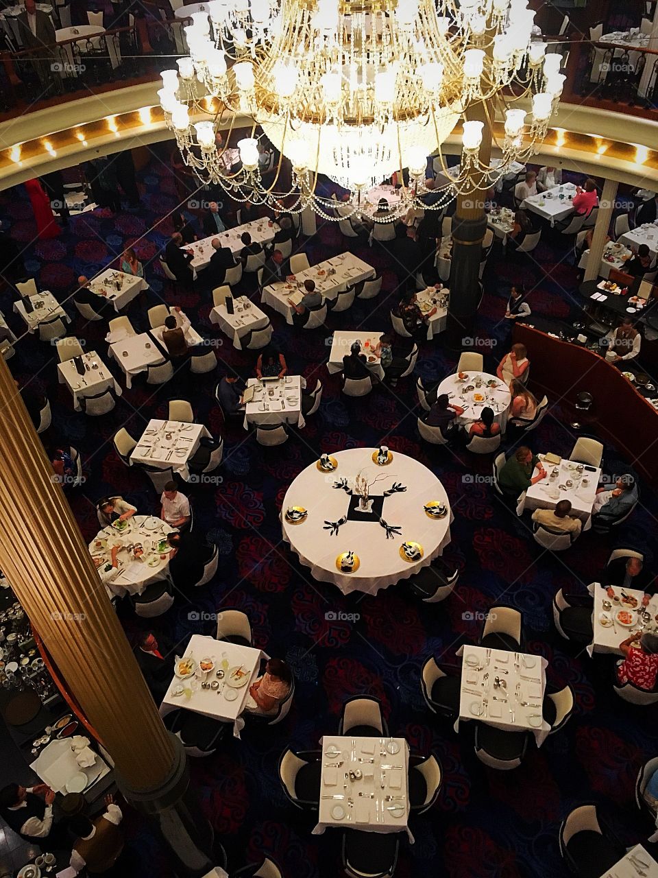 Looking down into the first floor of the main dining room onboard a cruise ship.  Black and white seems to be the theme and for some reason, the center table was always empty. 