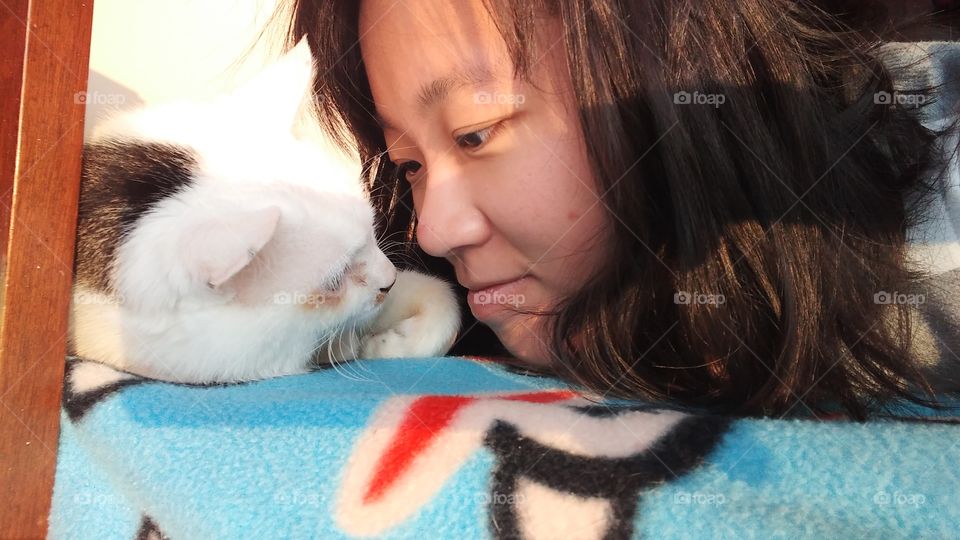 It is me and my domestic white cat. It is a heartwarming moment because it has been my company for more than 15 years.