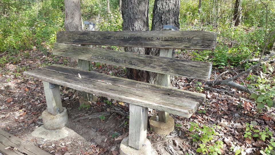 an old bench with a faded inscription of one of Lincoln's famous quotes, at the Abraham Lincoln Memorial Gardens