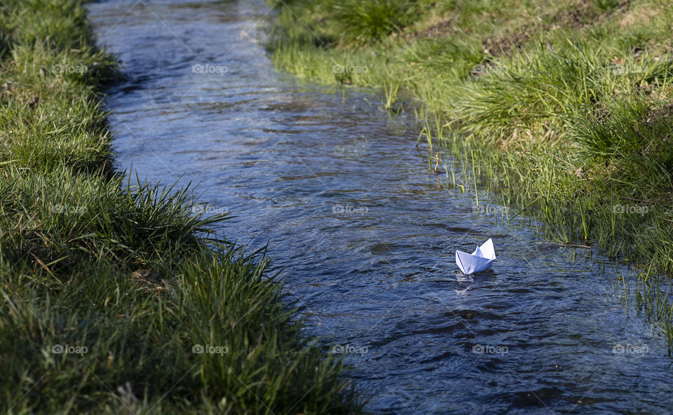 A paper boat floats on the stream