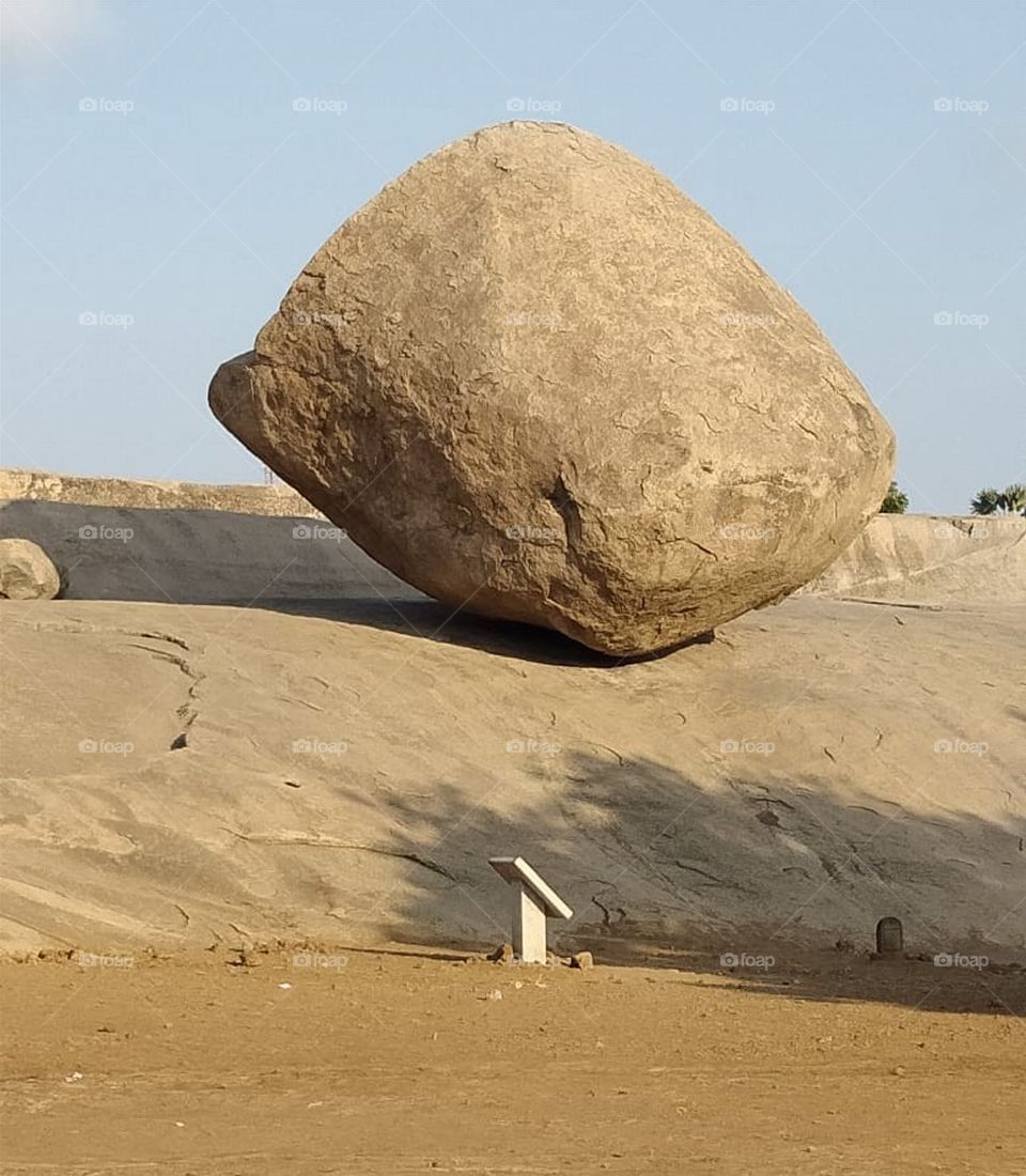 Krishna's Butter ball is a gigantic granite boulder resting on a short incline in the historical coastal resort town of mamallapuram in tamilnadu state of India. The boulder is approximately 6 meters high and 5 meters wide and weighs around 250 tons.