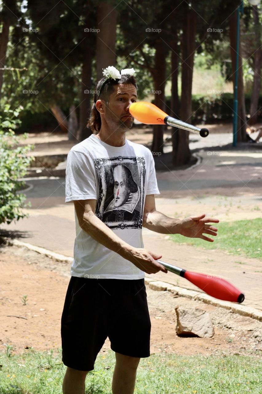 Funny father practice juggling, the camera catch the juggling pin in a funny position 