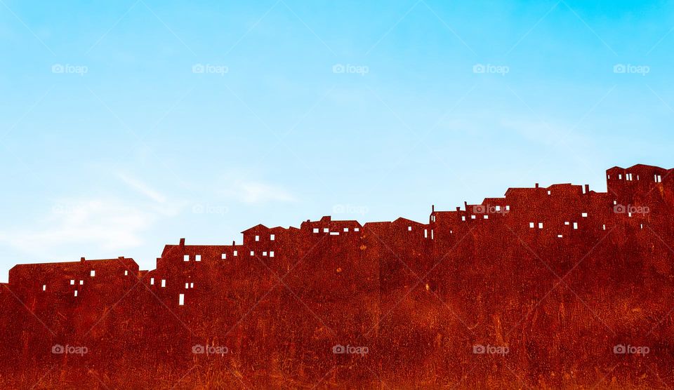 Metal signage depicting rooftops against a blue sky background