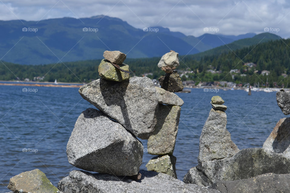 Stone stack overlooking ocean and west coast mountains near Vancouver
