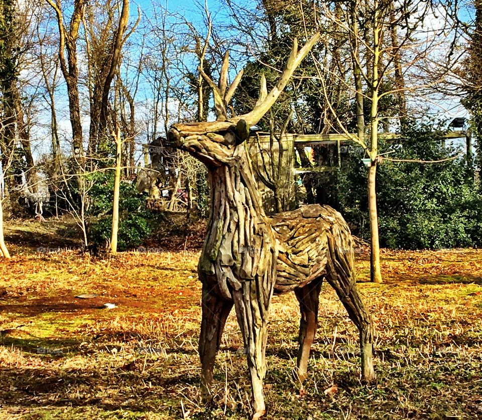 Life-sized  wooden Stag sculpture in the countryside 