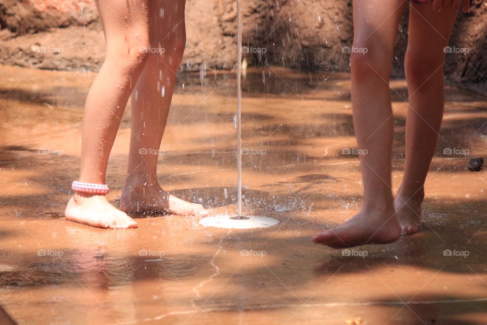 Two pair feet in splash park 