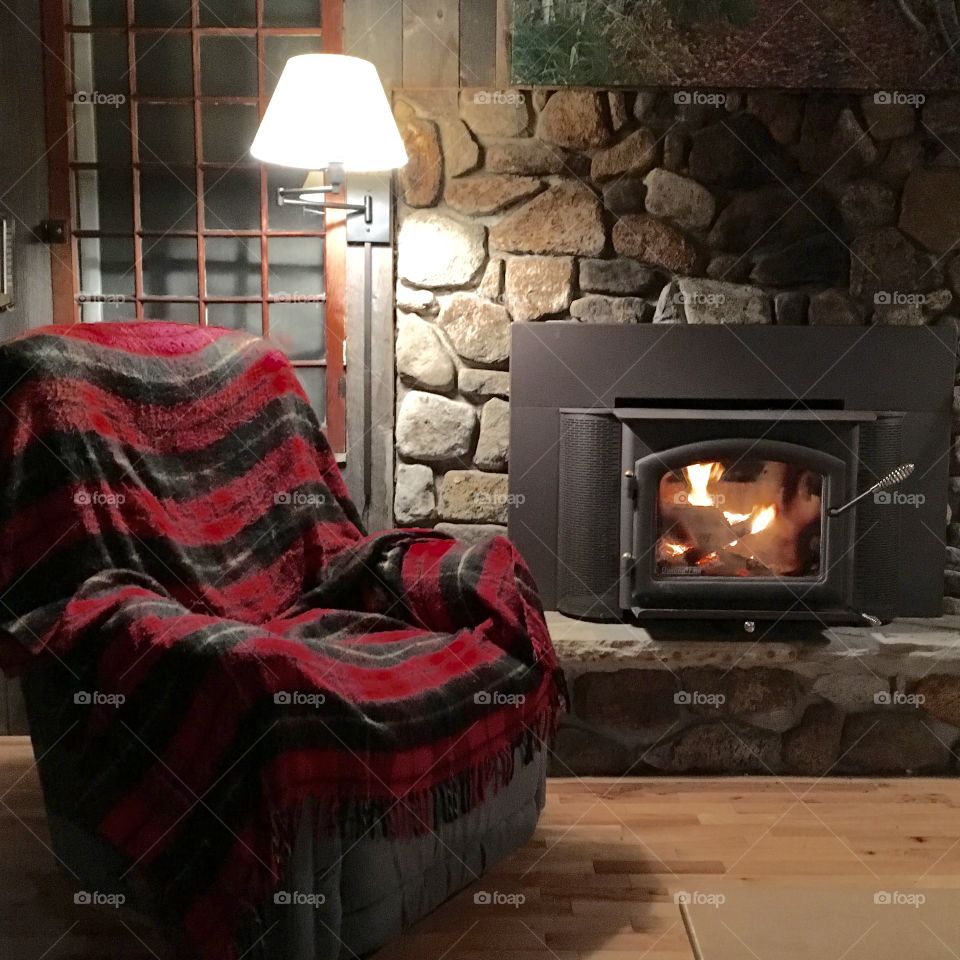 chair and blanket by cabin fireplace 