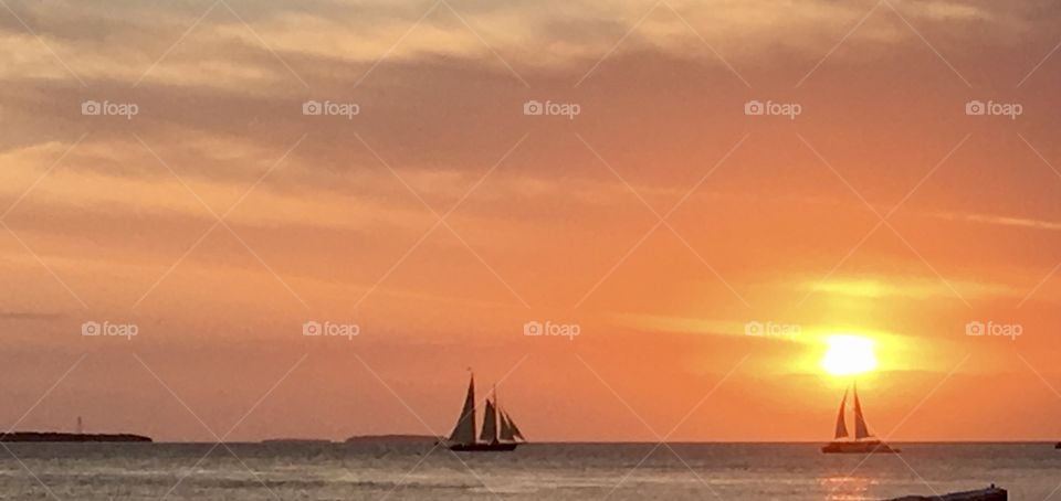 Sunset Sailboats .
Stunning  Key West sunset with sailboats holding fast to get the right pictures. 
A serene yet amazing scene. 
Does beauty get any better than this ?
Enjoy 