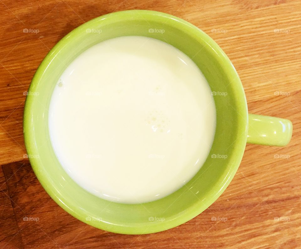 Warm milk in a green mug. Keeping warm this winter 