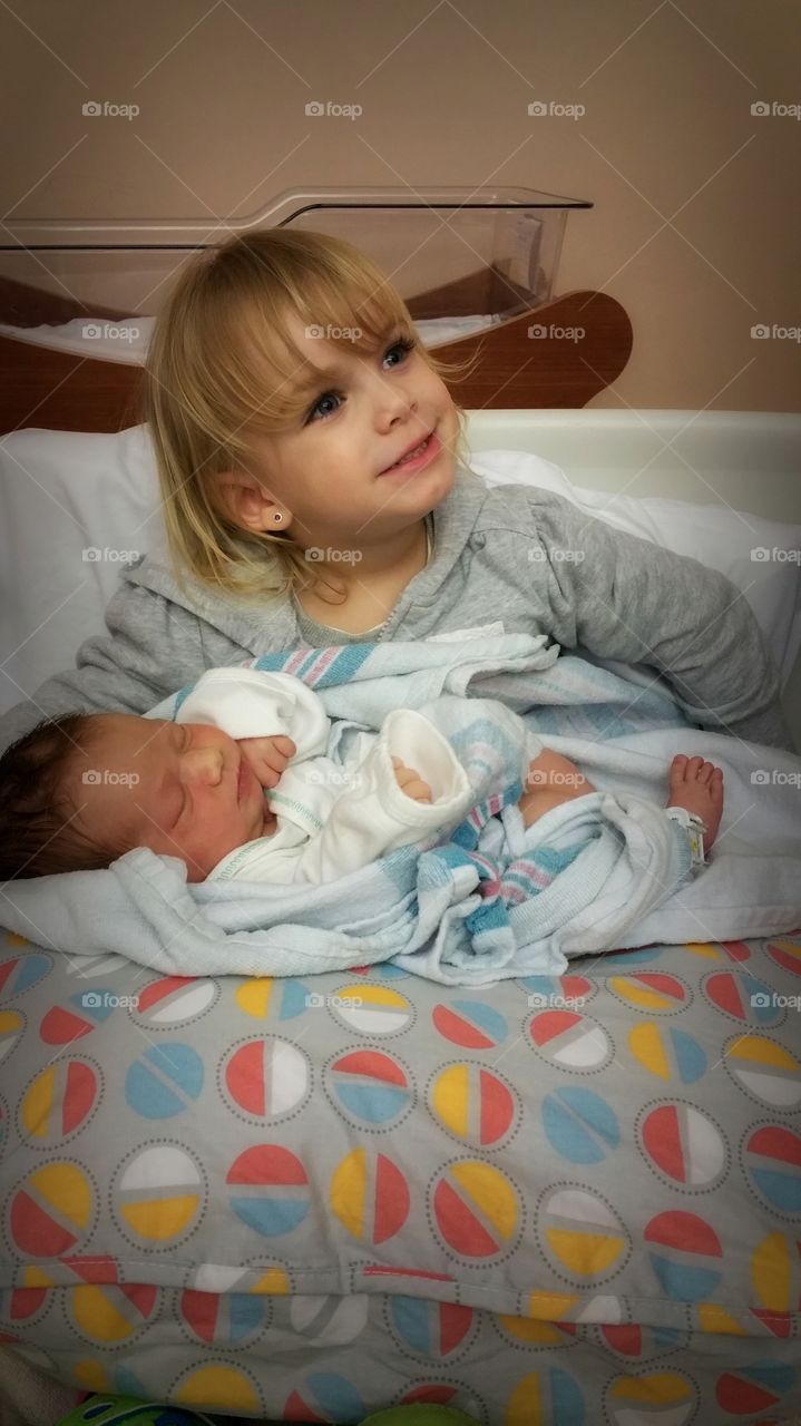 Cute girl with her newborn brother