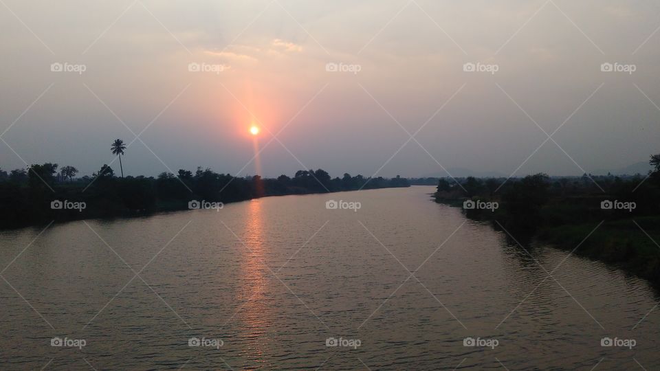 Sunset .
Beautiful sunset at riverside.
Sun with bright image in the river water.