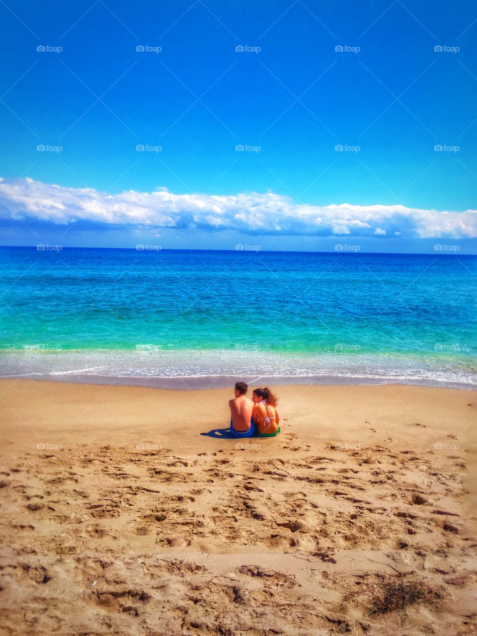Couple sitting down on the sand