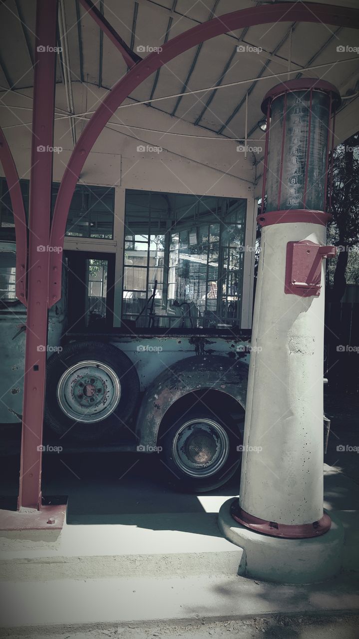 A historical city landmark gas station is placed in a history park. A vintage Ford truck forever parked waiting for an attendant to fill her up.