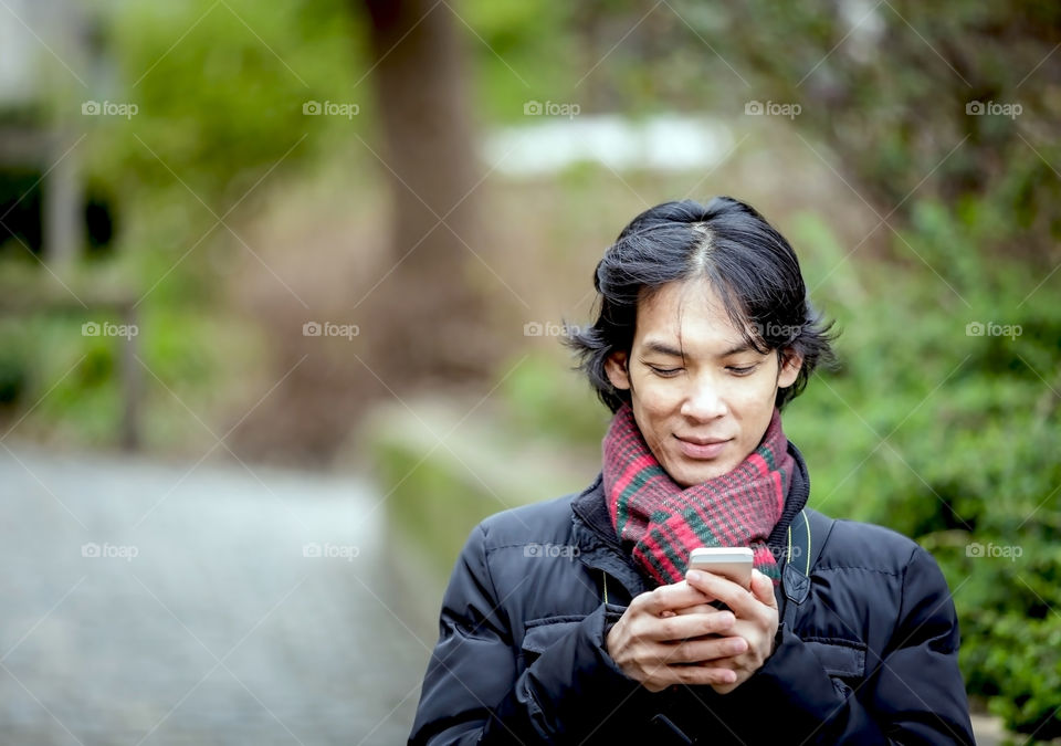 a man using smartphone on social networking in fall