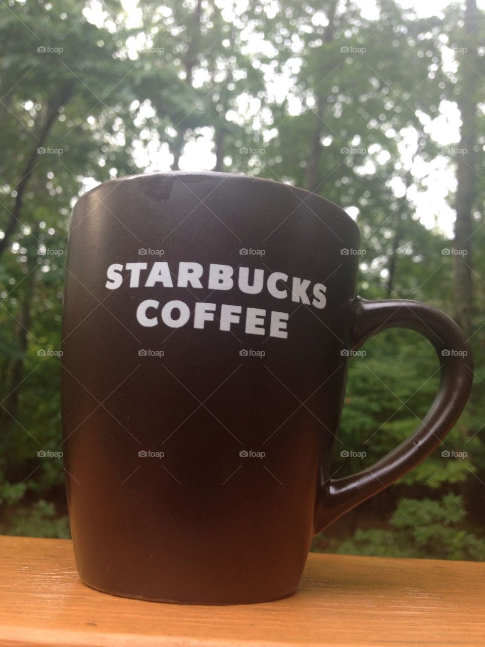 Good start of the day. Starbucks mug filled with coffee in the morning sun