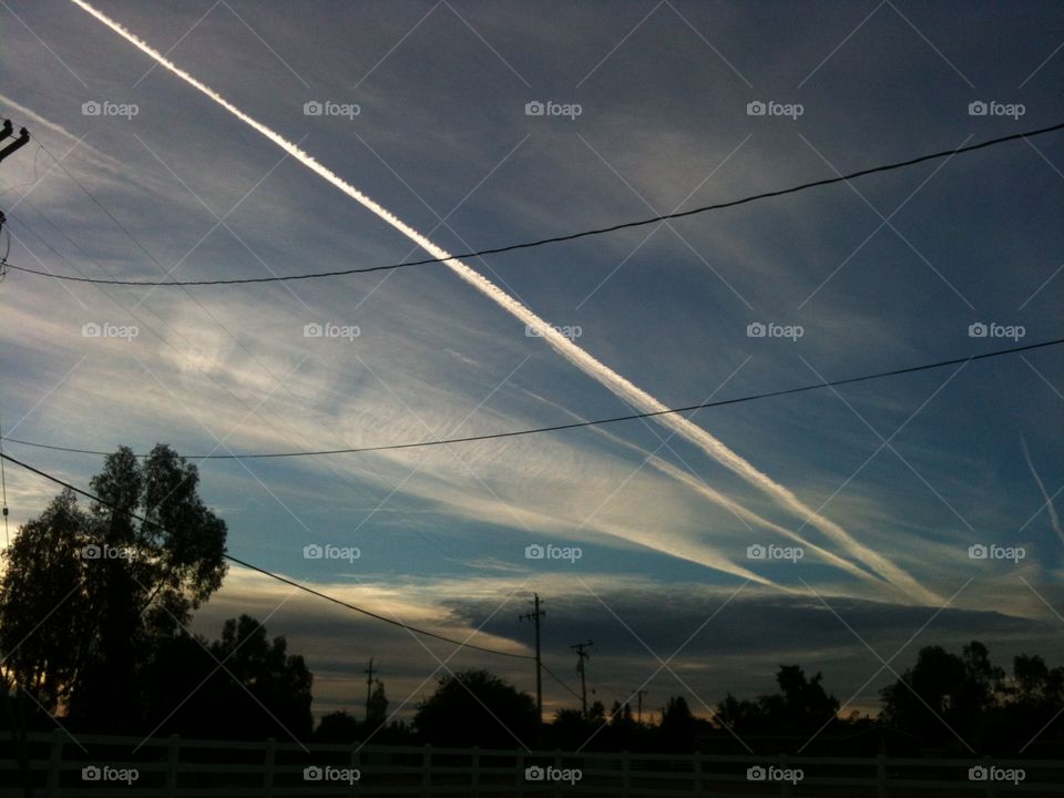 A break in the storm allows dusk to peek through the break in the gloomy sky, to reveal a luminous trail left behind an aviation enthusiast.