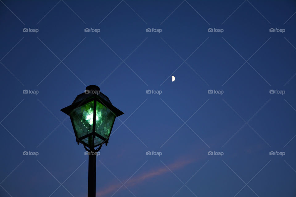 Two lights in the sky: a lamp and the Moon - Argegno, Como, Italy.
