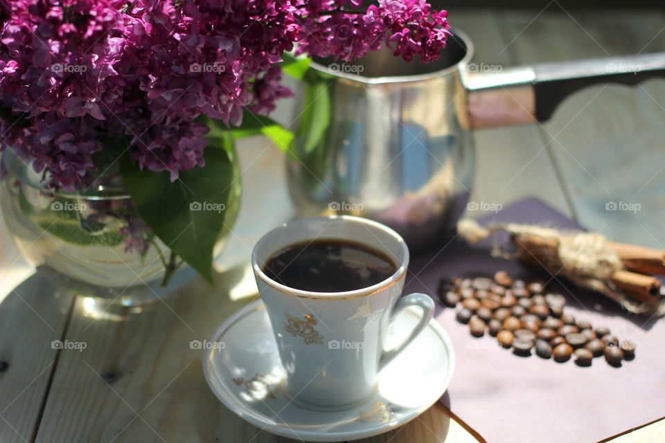 Cup of coffee with vase on table in restaurant