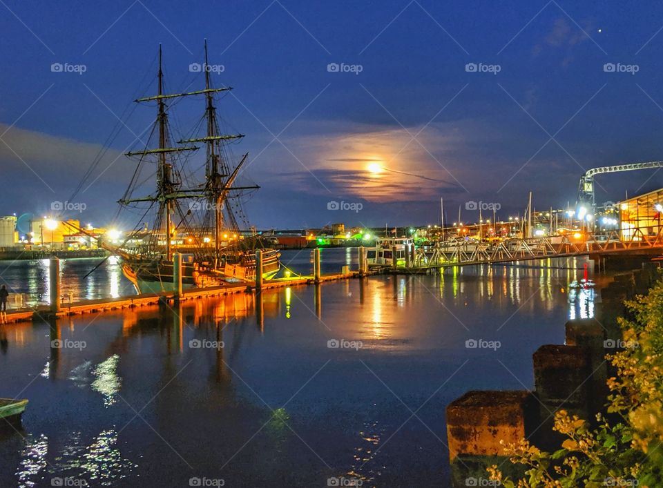 Beautiful & vintage tall ship during a full moon rising reflected on the water.
