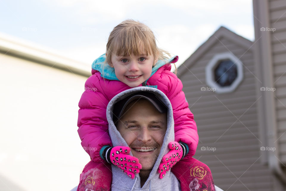 Father carrying his daughter on shoulders